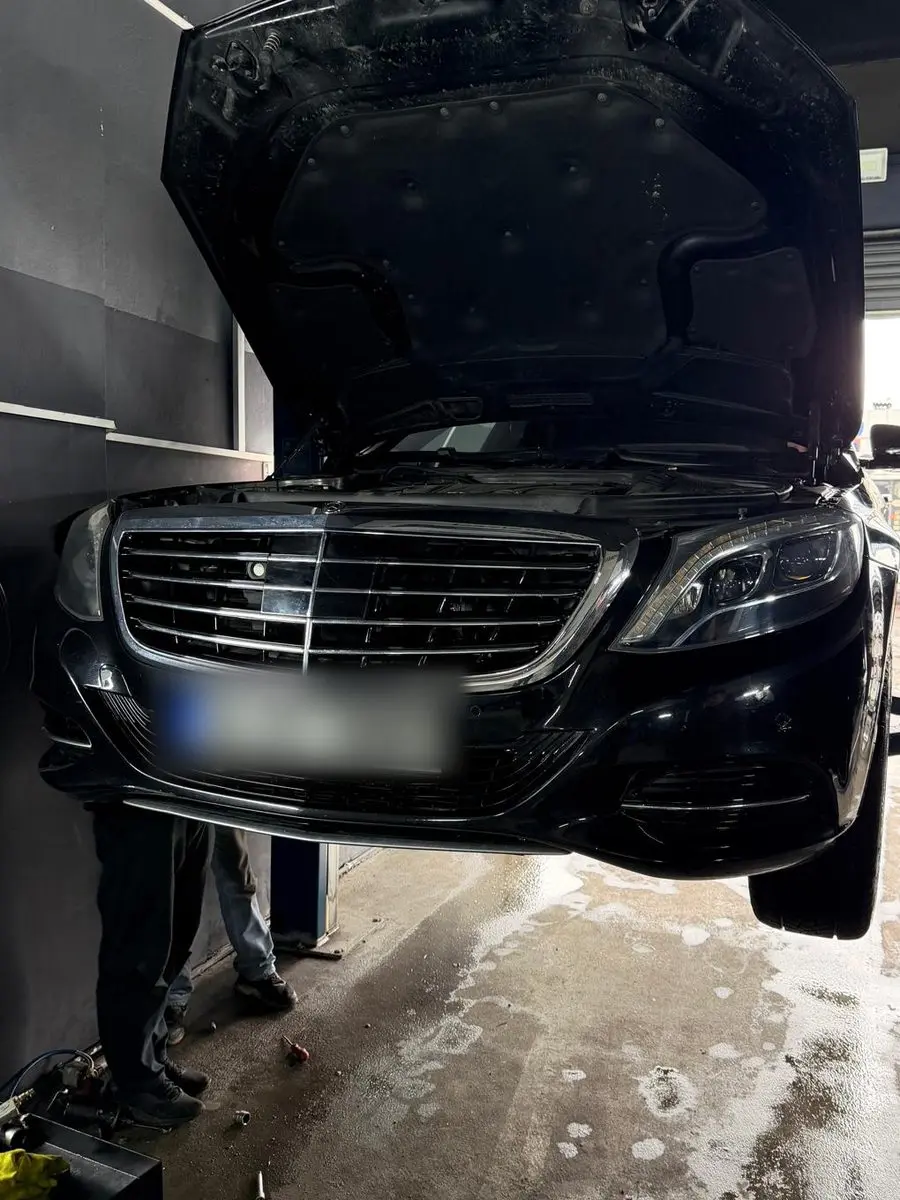 Kaputu açık halde lift üzerinde kaldırılmış siyah Mercedes S-Serisi
